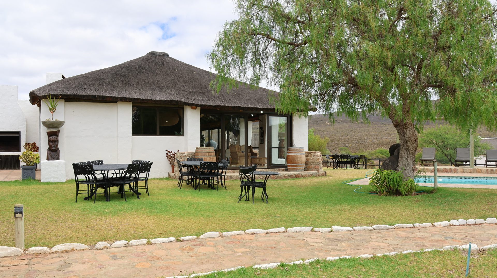 Lodge exterior with thatched roof and pool